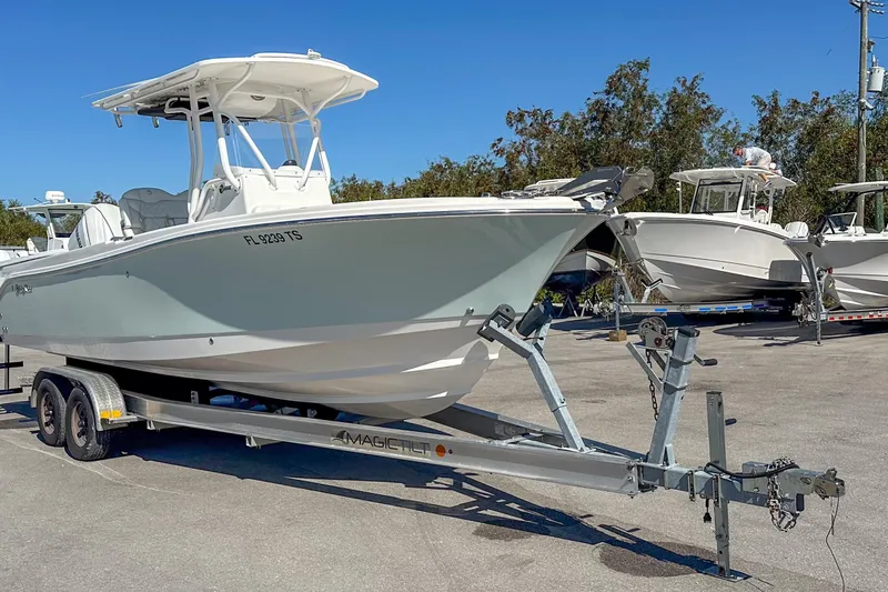 Slide: The Image of 2022 Edgewater 245CC boat on trailer in sunny outdoor setting. - 14