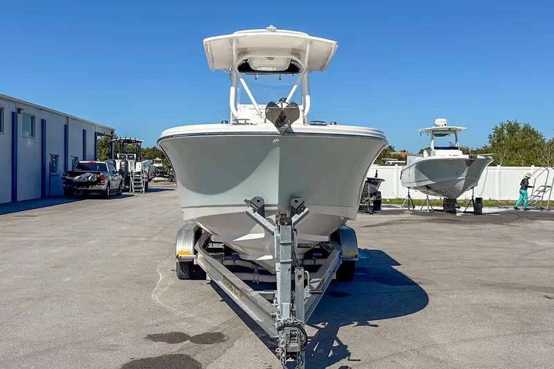 Slide: The Image of 2022 Edgewater 245CC boat on trailer in sunny outdoor setting. - 16