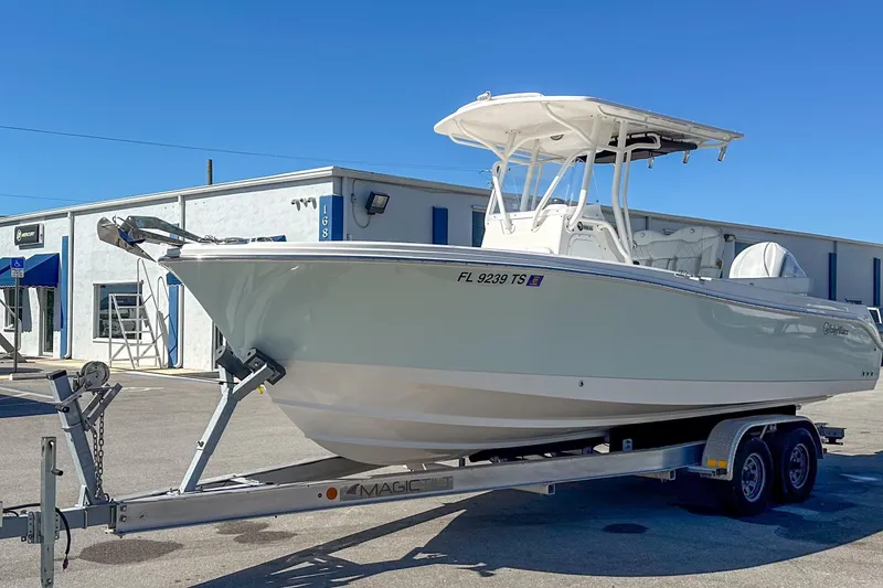 Slide: The Image of 2022 Edgewater 245CC boat on trailer, parked outside a building under clear blue sky. - 17