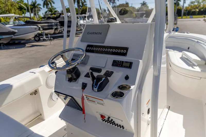 Slide: The Image of 2022 Edgewater 245CC boat console with Garmin navigation system and steering wheel. - 2