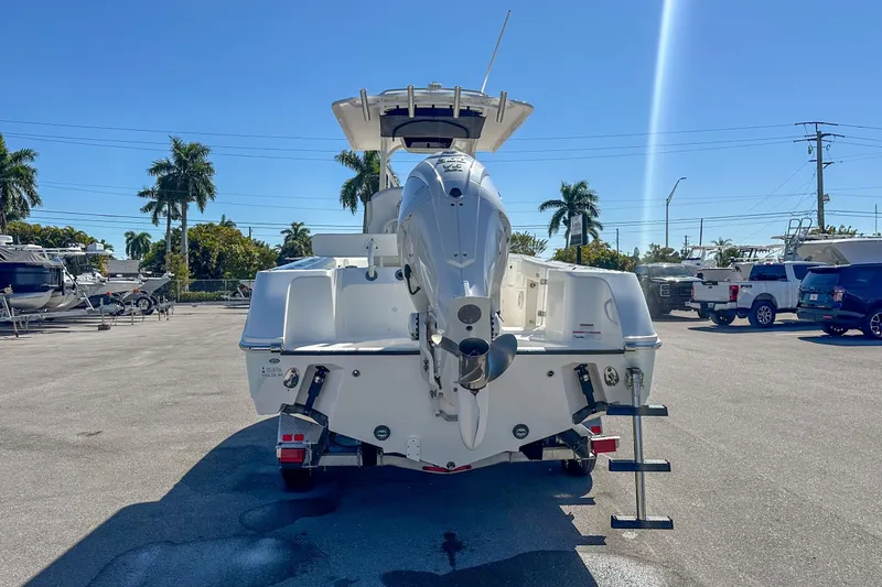 Slide: The Image of 2022 Edgewater 245CC boat rear view in sunny marina setting. - 20