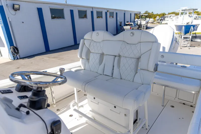 Slide: The Image of 2022 Edgewater 245CC boat interior with plush white seating and steering wheel. - 3