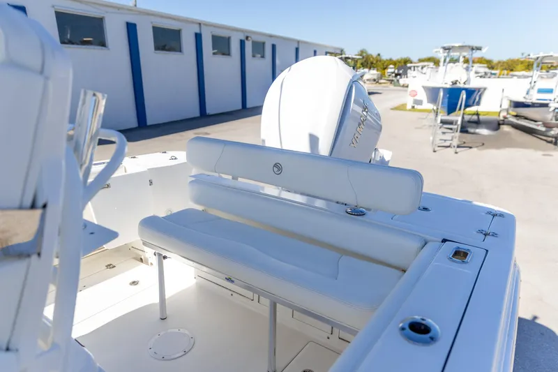 Slide: The Image of 2022 Edgewater 245CC boat with white seating and Yamaha engine in a marina setting. - 5