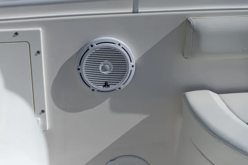 Slide: The Image of 2022 Edgewater 245CC boat interior with built-in speaker and cushioned seating. - 6
