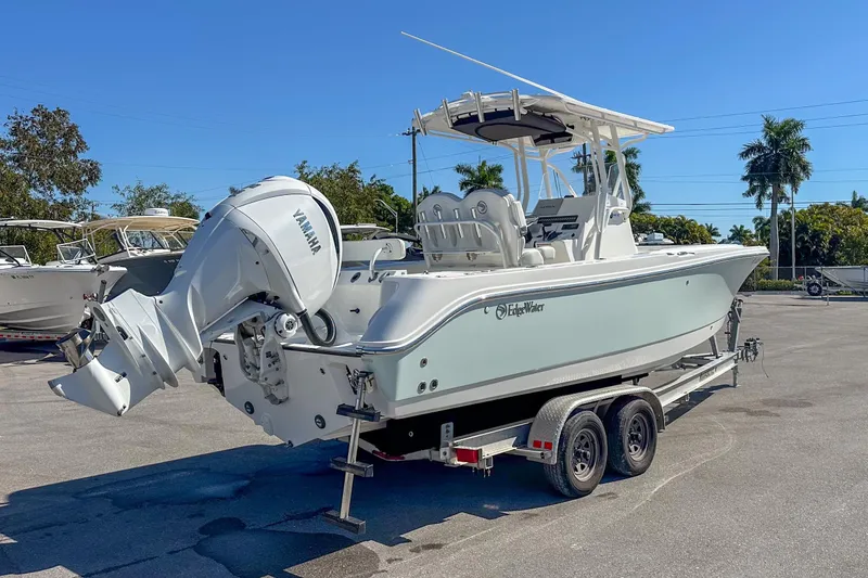 Slide: The Image of 2022 Edgewater 245CC boat on trailer with Yamaha outboard, parked outdoors. - 9