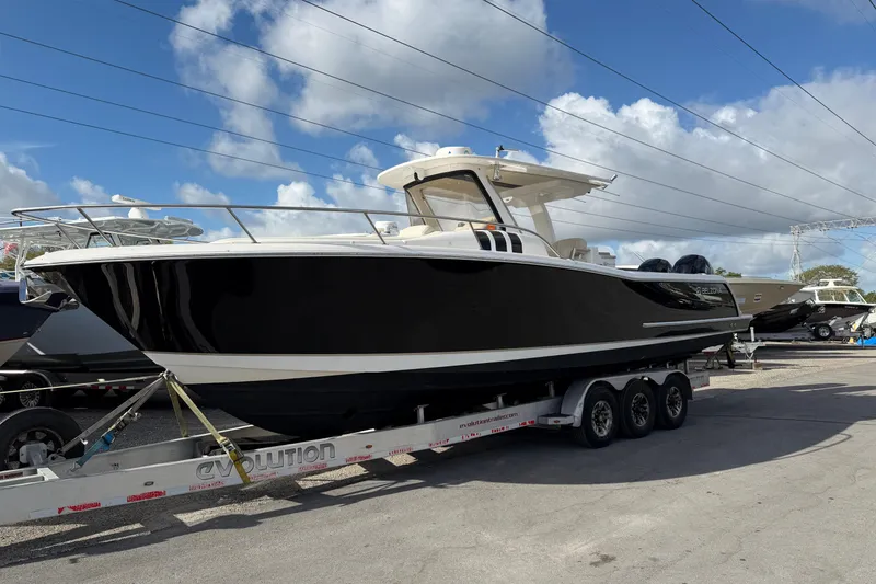 The Image of 2015 Belzona 32 Walkaround boat on trailer under blue sky. - 1