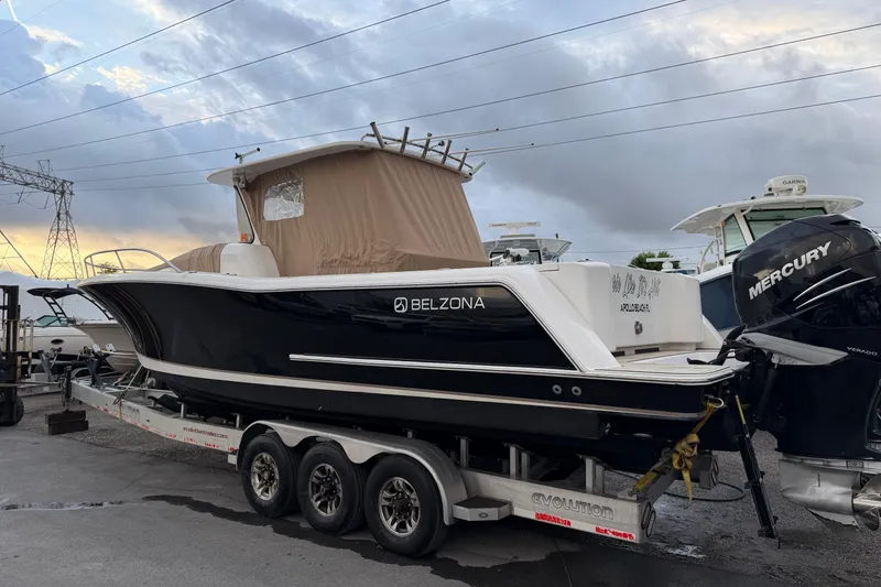 Slide: The Image of 2015 Belzona 32 Walkaround boat on trailer, featuring Mercury outboard engines. - 13