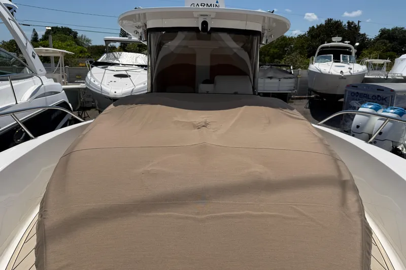 Slide: The Image of 2015 Belzona 32 Walkaround boat with covered deck, docked among other vessels. - 22