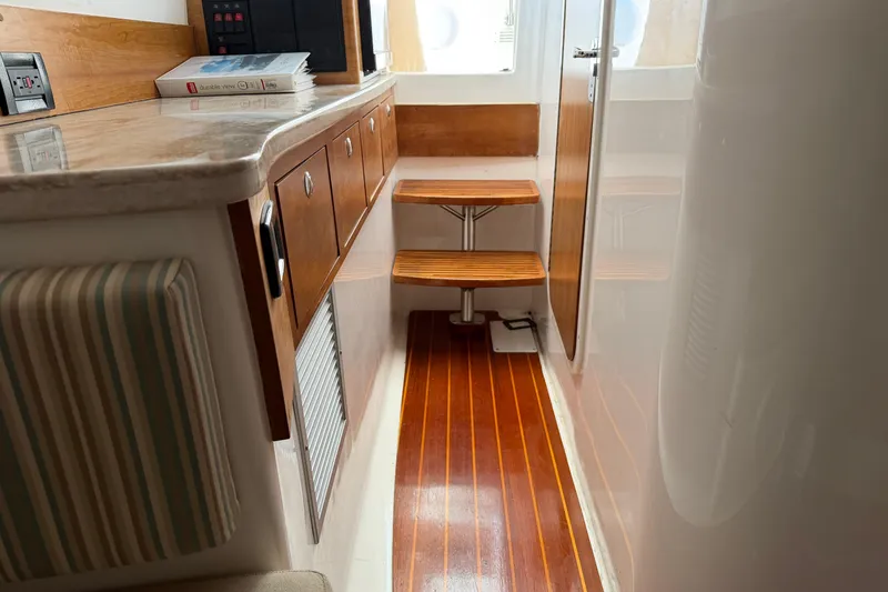 Slide: The Image of Interior of 2015 Belzona 32 Walkaround boat with wooden steps and cabinetry. - 23
