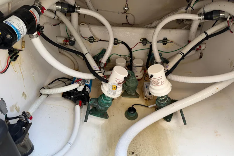 Slide: The Image of Engine compartment of a 2015 Belzona 32 Walkaround boat with visible hoses and pumps. - 26