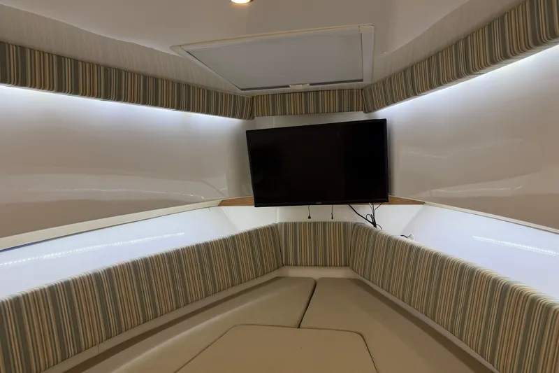 Slide: The Image of Interior of 2015 Belzona 32 Walkaround boat with striped seating and mounted TV. - 29