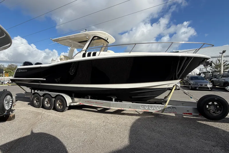 Slide: The Image of 2015 Belzona 32 Walkaround boat on trailer under cloudy sky. - 4
