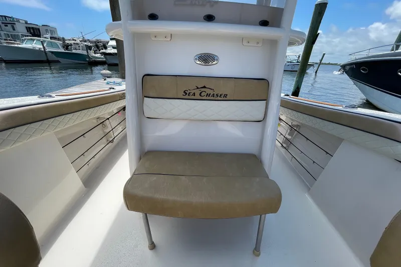 Slide: The Image of 2023 Sea Chaser 24 HFC boat interior with cushioned seating at marina. - 10