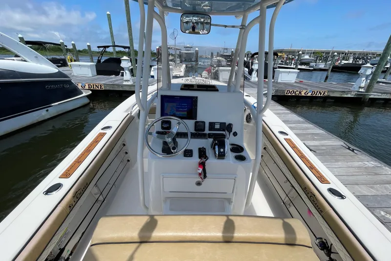 Slide: The Image of 2023 Sea Chaser 24 HFC boat interior at marina dock, featuring steering console. - 13