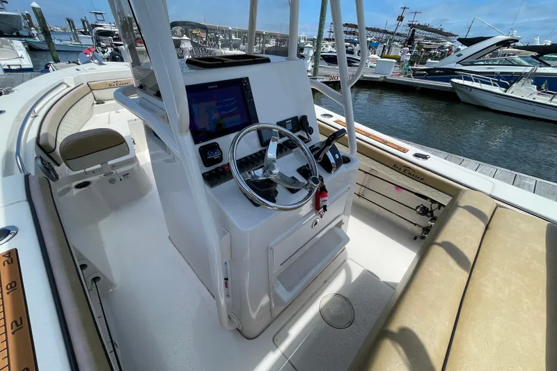 Slide: The Image of 2023 Sea Chaser 24 HFC boat interior with steering console and seating at marina. - 14