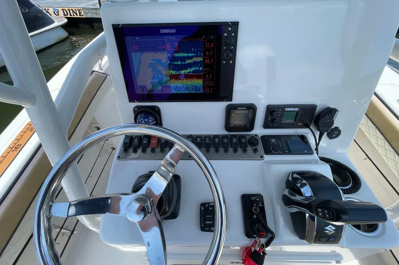 Slide: The Image of 2023 Sea Chaser 24 HFC boat dashboard with steering wheel and navigation controls. - 16