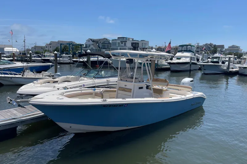 Slide: The Image of 2023 Sea Chaser 24 HFC boat docked in a marina, surrounded by other vessels. - 2