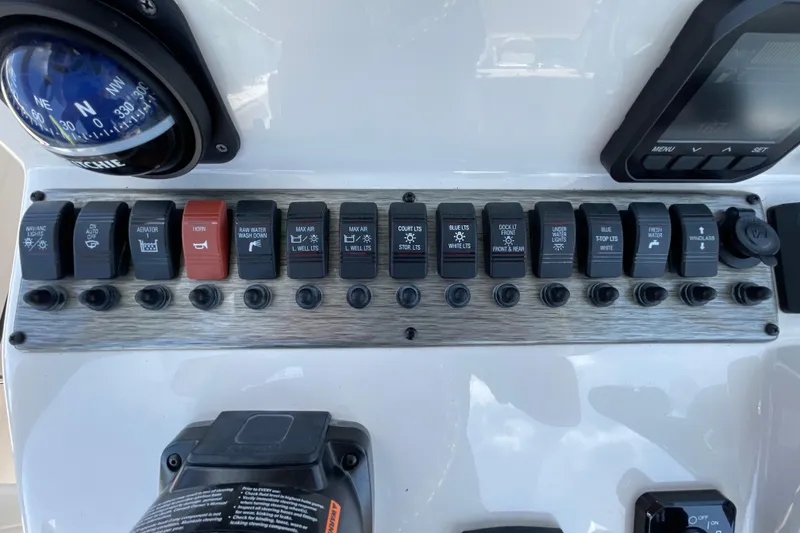 Slide: The Image of Control panel of 2023 Sea Chaser 24 HFC boat with switches and compass. - 21