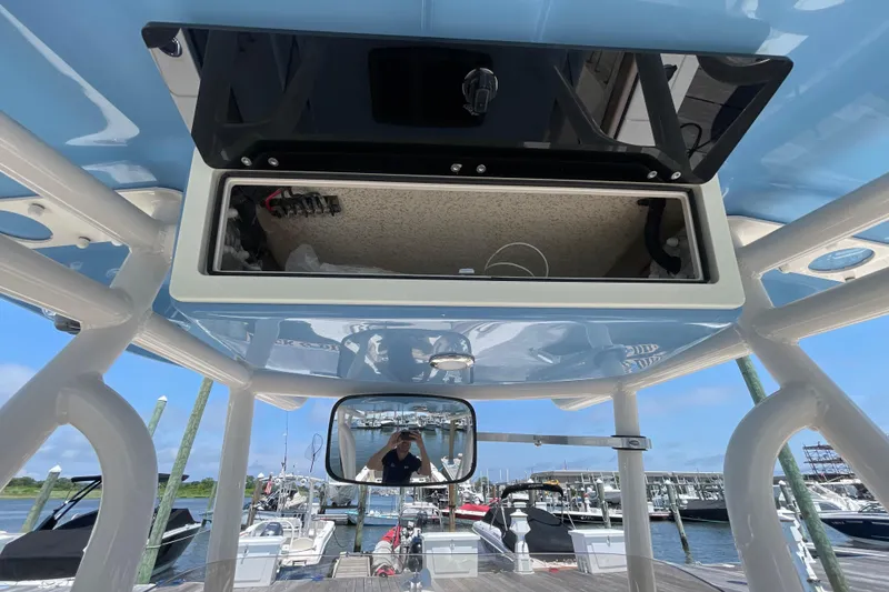 Slide: The Image of 2023 Sea Chaser 24 HFC boat console with open storage compartment at marina. - 25