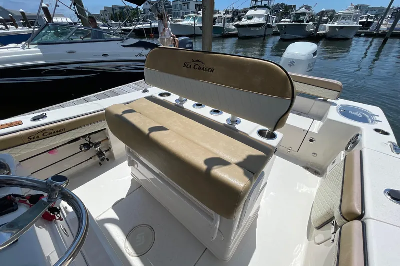 Slide: The Image of 2023 Sea Chaser 24 HFC boat interior with tan seating and fishing rod holders. - 26