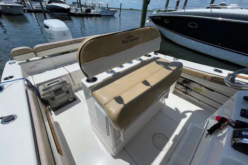 Slide: The Image of 2023 Sea Chaser 24 HFC boat interior with tan seating, docked at marina. - 27