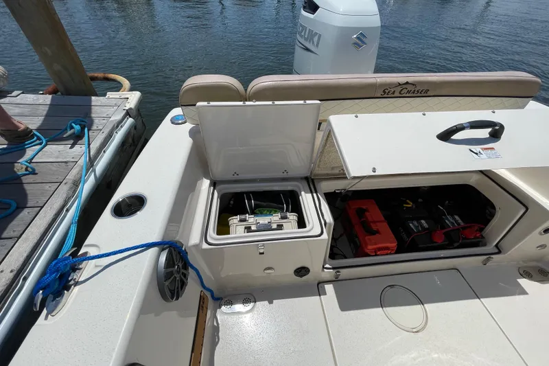 Slide: The Image of 2023 Sea Chaser 24 HFC boat with open storage compartments at the dock. - 33