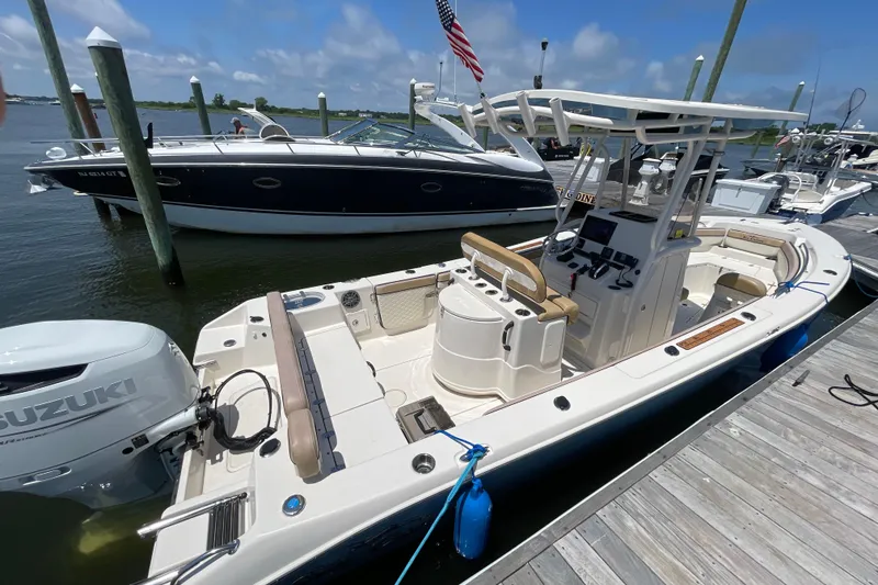 Slide: The Image of 2023 Sea Chaser 24 HFC boat docked, featuring a Suzuki outboard motor. - 37