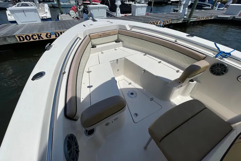 Slide: The Image of 2023 Sea Chaser 24 HFC boat interior with cushioned seating at dock. - 4