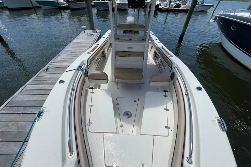 Slide: The Image of 2023 Sea Chaser 24 HFC boat docked, showcasing spacious deck and seating area. - 5