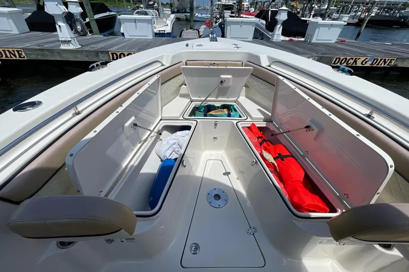 Slide: The Image of 2023 Sea Chaser 24 HFC boat with open storage compartments at a marina. - 6