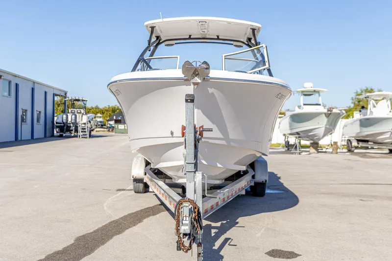Slide: The Image of 2025 Edgewater 248CX Crossover boat on trailer in marina setting. - 10