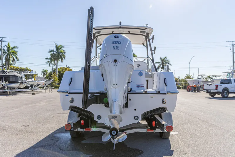 Slide: The Image of 2025 Edgewater 248CX Crossover boat with powerful outboard motor in sunny marina. - 13