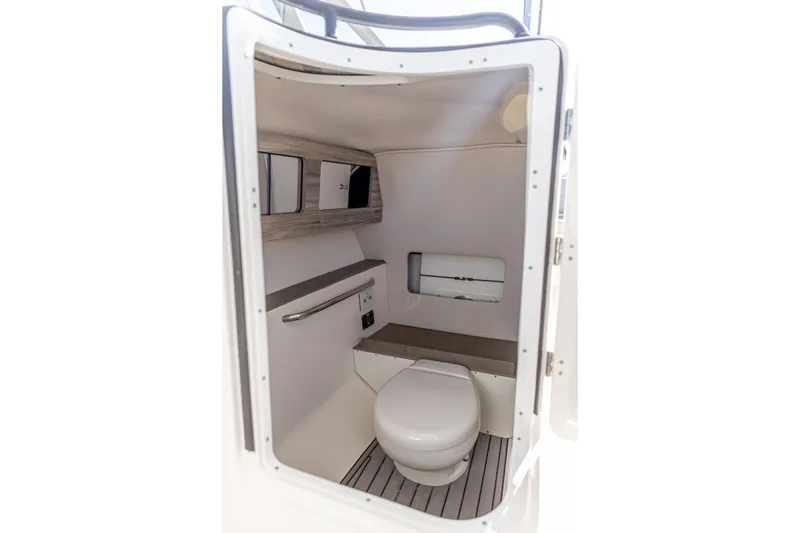 Slide: The Image of Interior of 2025 Edgewater 248CX Crossover boat's compact bathroom space. - 16