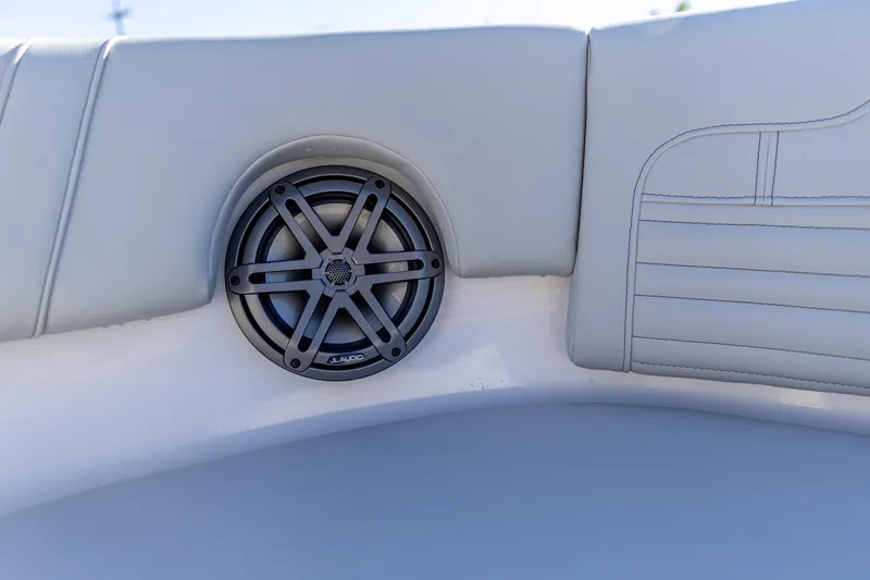 Slide: The Image of Speaker on 2025 Edgewater 248CX Crossover boat with white cushioned seating. - 18