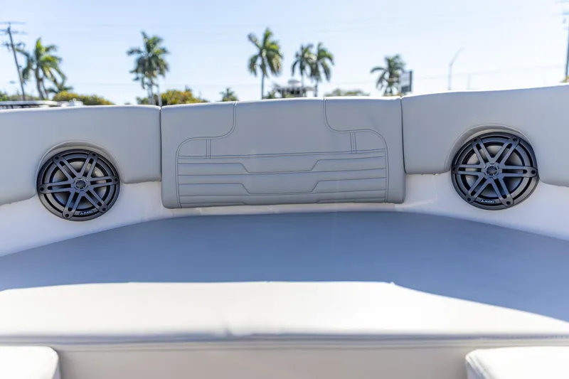 Slide: The Image of Interior of 2025 Edgewater 248CX Crossover boat with speakers and cushioned seating. - 19