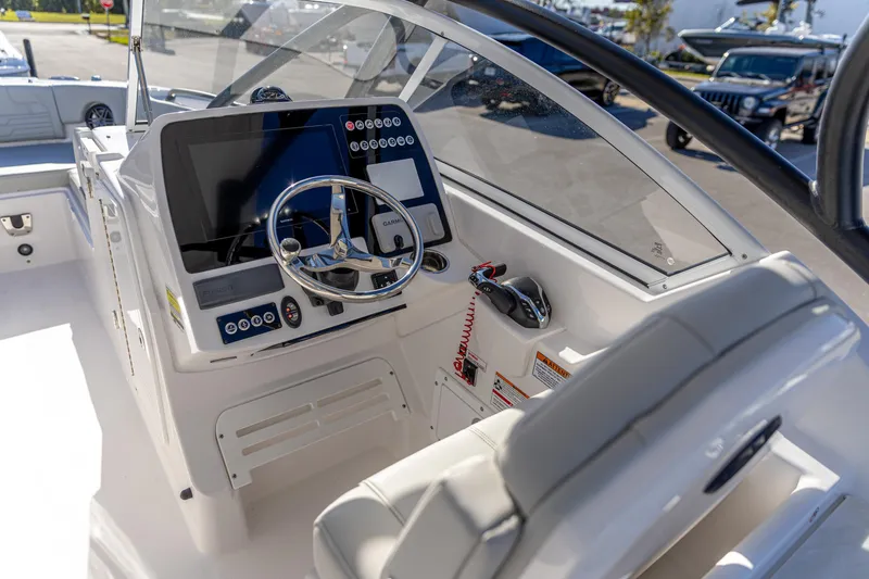 Slide: The Image of 2025 Edgewater 248CX Crossover boat cockpit with modern steering and navigation controls. - 3