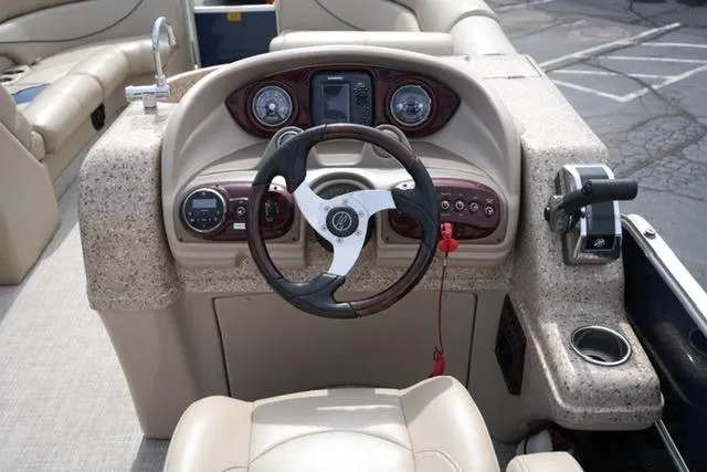 Slide: The Image of Steering console of a 2012 South Bay 722CR boat with beige and brown accents. - 10