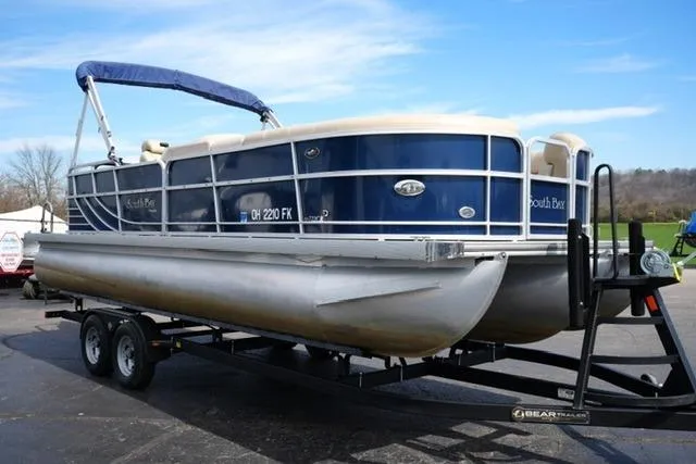 Slide: The Image of 2012 South Bay 722CR pontoon boat on trailer, blue and white design, outdoor setting. - 3