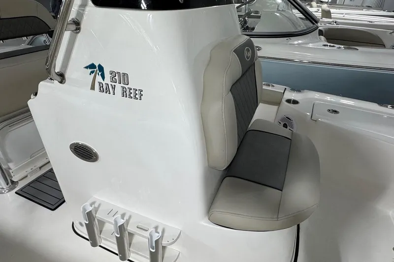 Slide: The Image of 2026 Key West 210 Bay Reef boat interior with cushioned seating and rod holders. - 9
