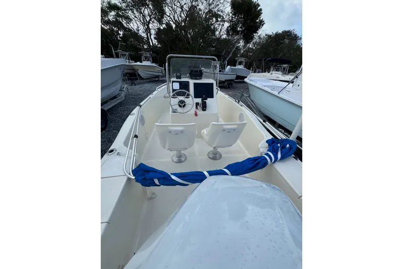 Slide: The Image of 2001 Scout 175 Sportfish boat with console and seating, docked among other boats. - 3