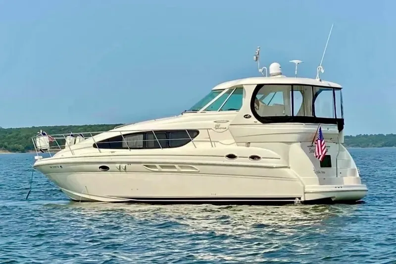 Slide: The Image of 2003 Sea Ray 390 Motor Yacht on calm water, featuring sleek design and American flag. - 1