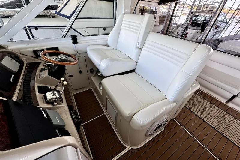 Slide: The Image of Captain's helm of 2003 Sea Ray 390 Motor Yacht with white leather seating and wooden accents. - 4