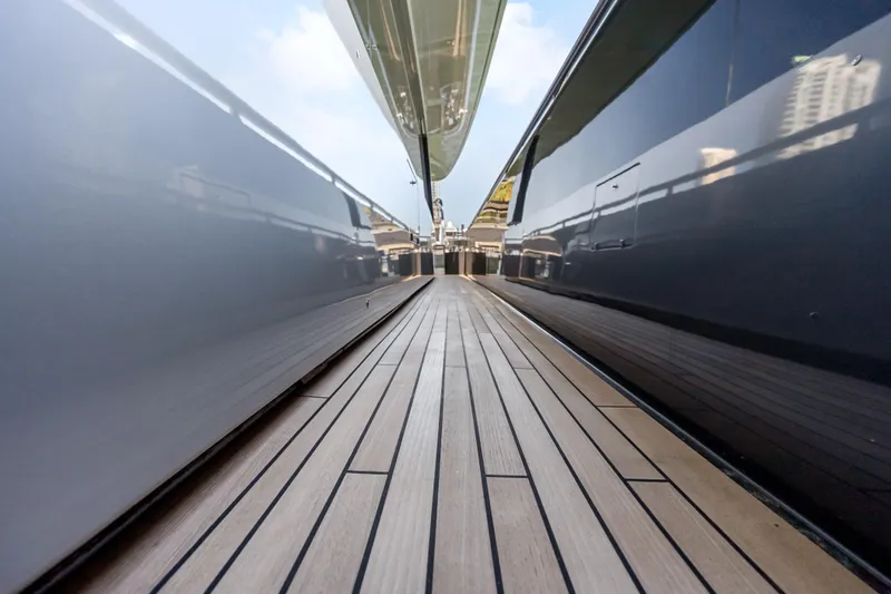 Slide: The Image of Side deck view of 2020 Riva 100' Corsaro yacht with sleek design and wooden flooring. - 21