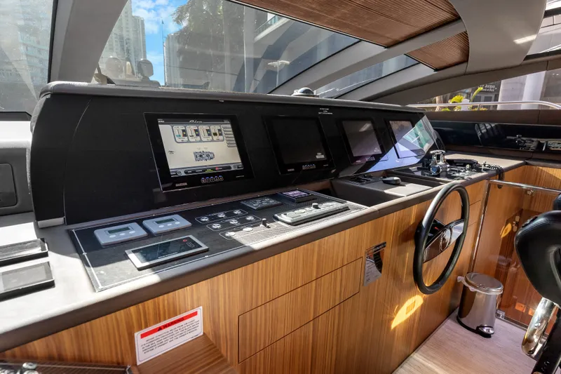 Slide: The Image of Cockpit of 2020 Riva 100' Corsaro yacht with modern navigation controls and sleek wood finish. - 32