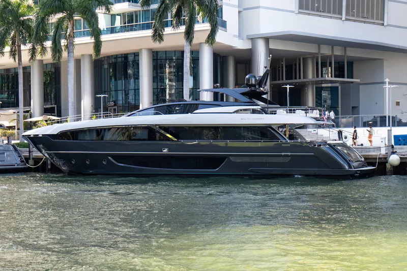 Slide: The Image of Luxury 2020 Riva 100' Corsaro yacht docked by modern waterfront building. - 5