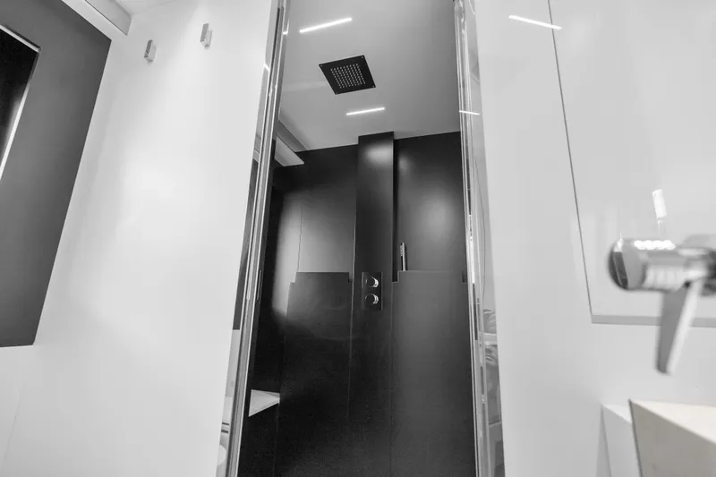 Slide: The Image of Modern bathroom interior on 2020 Riva 100' Corsaro yacht, featuring sleek black and white design. - 69