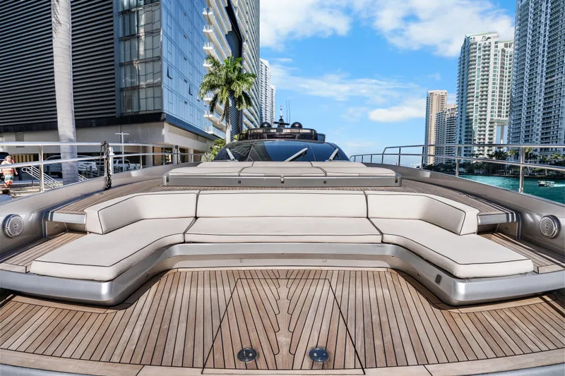 Slide: The Image of Luxurious 2020 Riva 100' Corsaro yacht deck with elegant seating, city skyline backdrop. - 7