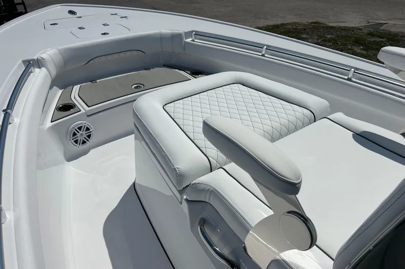 Slide: The Image of 2026 Sportsman Masters 247OE Bay Boat interior with white quilted seating and cup holders. - 13