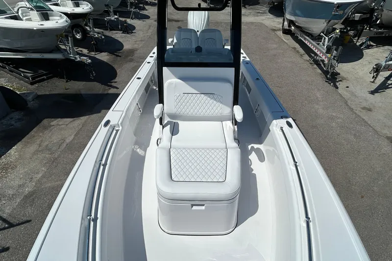 Slide: The Image of 2026 Sportsman Masters 247OE Bay Boat with cushioned seating, docked among other boats. - 14