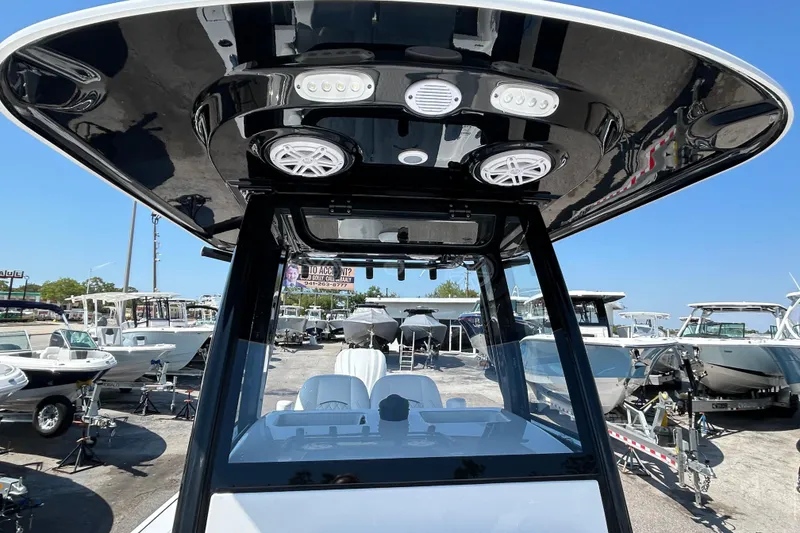 Slide: The Image of 2026 Sportsman Masters 247OE Bay Boat with advanced console and speakers, docked at marina. - 16